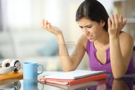 Photo for Frustrated student complaining checking notes at home - Royalty Free Image