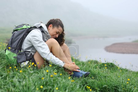 Photo for Single hiker suffering ankle ache after strumbling in nature - Royalty Free Image