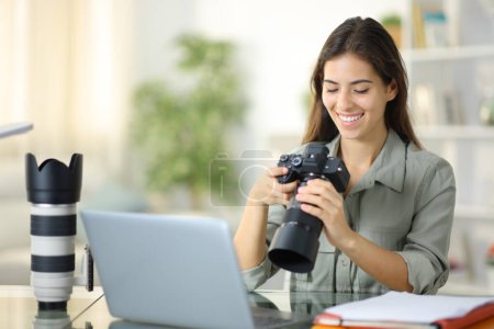 Happy online student of photography checking results on camera at home