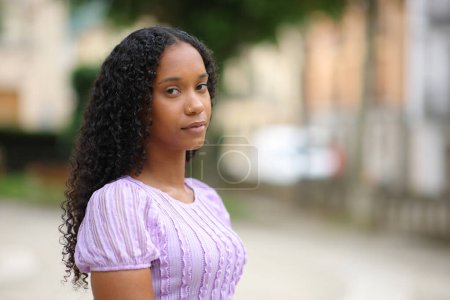 Serious black woman looks at you standing in the street alone