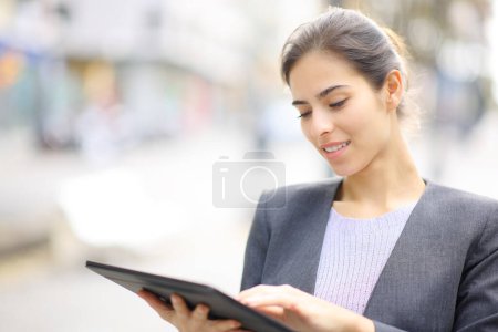 Photo for Executive using tablet standing in the street - Royalty Free Image