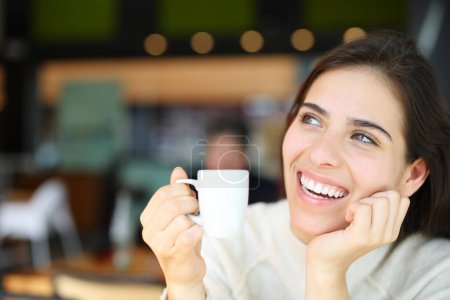 Foto de Mujer feliz con dientes perfectos soñando y bebiendo café en el interior de un restaurante - Imagen libre de derechos