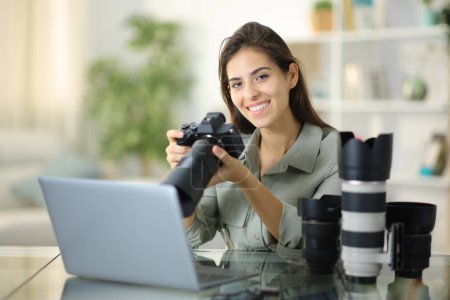 Happy freelance photographer posing looking at camera at home