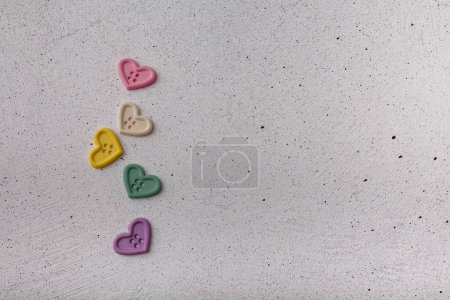 Photo for Multicolored decorative heart-shaped buttons on white background. Ornamental details for sewing, scrapbooking, handmade - Royalty Free Image