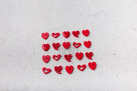 Photo for Set of red decorative heart-shaped buttons on white background. Ornamental details for sewing, scrapbooking, handmade - Royalty Free Image