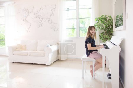Photo for Child playing piano. Kids play music. Classical education for children. Art lesson. Little girl at white digital keyboard. Instrument for young student. Music class in school or at home. - Royalty Free Image