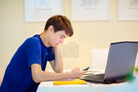 Photo for Homeschooling. Kids learning from home. Remote school, online education for high school child during quarantine. College student with laptop and tablet computer. Teenager boy doing homework. - Royalty Free Image