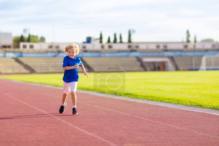 Photo for Child running in stadium. Kids run on outdoor track. Healthy sport activity for children. Little boy at athletics competition race. Young athlete in training. Runner exercising. Jogging for kid. - Royalty Free Image