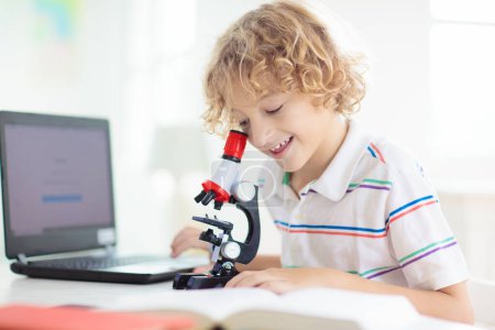 Photo for School kids with microscope. Science class. Children making biology or chemistry experiment with laptop computer. Online learning. Remote studying for elementary school child. Boy looking at subject. - Royalty Free Image