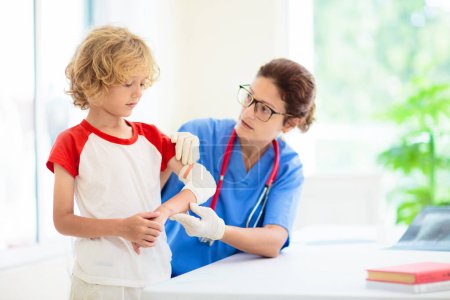Photo for Child with arm injury at trauma and emergency care. Kid with elbow cast at health clinic. Doctor checking x-ray of injured little boy. Kids hospital. - Royalty Free Image