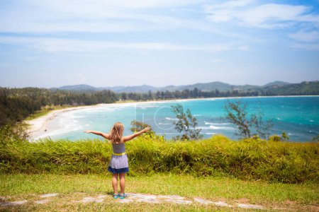 Child hiking on tropical island. Sea and mountain view from top of a hill. Kids hike. Active summer vacation with children. Trekking holiday with young kid. Travel to Asia.