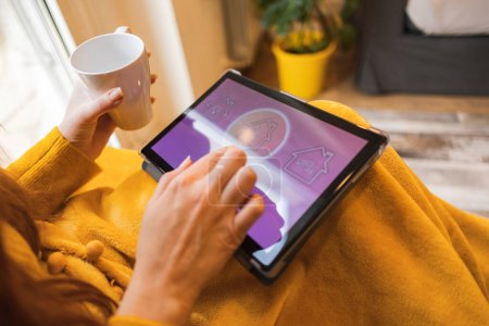 Schließen Sie die Hände mit einem Tablet. Frau lebt in Smart-Home-Automation und nutzt Technologie und Apps zur Steuerung von Beleuchtung und Sicherheit