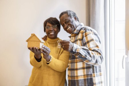 Photo for Senior couple with house key, African Americans moving into their new home, post retirement, home buying. - focus on keys - - Royalty Free Image