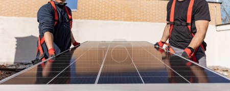 Foto de Dos trabajadores manuales que instalan el panel solar - Imagen libre de derechos