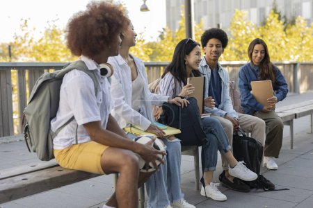 Téléchargez les photos : Groupe de camarades de classe multiraciaux se réunissant sur le campus à la pause - échanger des étudiants - - en image libre de droit