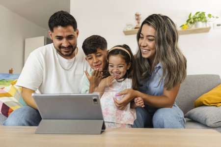 hispanic family with children make video call laptop computer sitting on sofa at home