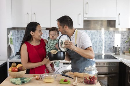 Photo for Happy family in the kitchen while doing housework together - Royalty Free Image