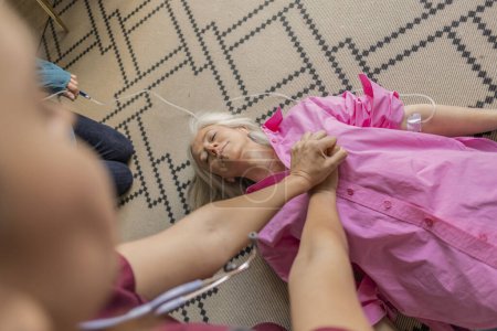 Foto de RCP de emergencia de primeros auxilios a una mujer que sufre un ataque cardíaco: mujer mayor acostada en el suelo en proceso de resucitación - Imagen libre de derechos