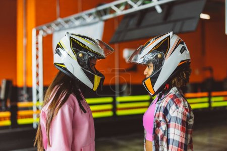 Photo for Go-Kart Racers helmet challenge fight two women staring at each other to win - Royalty Free Image