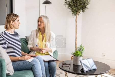 Friends or colleagues enjoying a coffee break and a chat in a modern living room with comfortable decor.