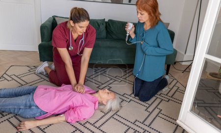 Une infirmière effectue une RCR sur une dame âgée à la maison pendant qu'un autre adulte prépare une injection.