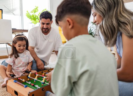 Una familia alegre jugando futbolín, creando recuerdos