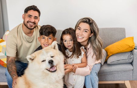 Eine glückliche Familie posiert mit ihrem flauschigen Hund und teilt ihr Lächeln.