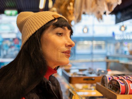 Eine Frau mit besinnlichem Blick, umgeben von Marktatmosphäre.