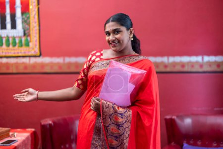 Téléchargez les photos : Femme indienne confiante dans un saree traditionnel tenant du matériel éducatif, prête à présenter. - en image libre de droit
