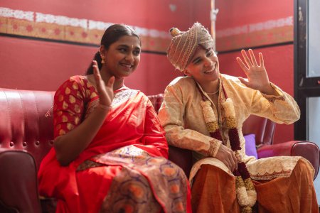 Jeunes gens en tenue traditionnelle indienne partageant un accueil ludique, rayonnant de joie culturelle.
