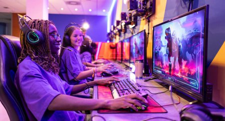 A joyful young woman with headphones plays an intense fantasy game on a vibrant gaming setup.