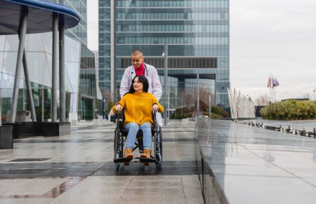 A dedicated doctor pushes a patient's wheelchair, providing assistance and care amidst the urban landscape.