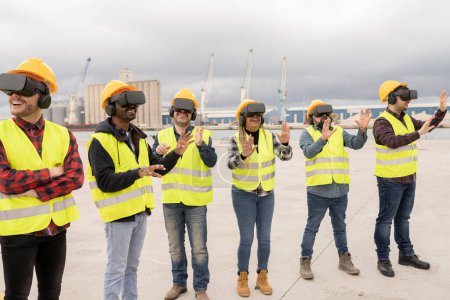 A diverse group of six construction workers engaging with virtual reality technology at an industrial site.