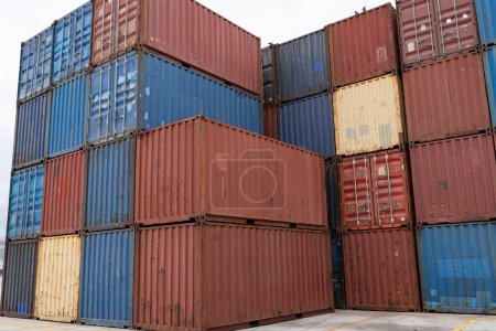 Des conteneurs de fret empilés de couleur vive dans un chantier naval, illustrant le commerce mondial et la logistique.