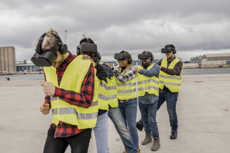 Trabajadores de la construcción disfrutan de una sesión de realidad virtual lúdica e interactiva, mejorando la dinámica del equipo en un puerto.