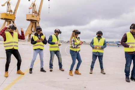 Cinco profesionales de la construcción realizan un ejercicio de VR colaborativo en un puerto industrial, mostrando el trabajo en equipo y la tecnología.