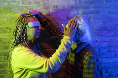 Deux personnes âgées avec des lunettes VR, profondément engagées dans une expérience colorée et interactive.