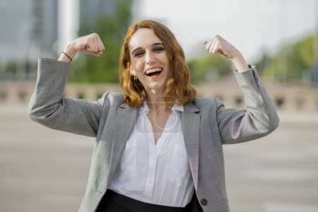 Empowered young businesswoman joyfully celebrating a professional achievement outdoors.