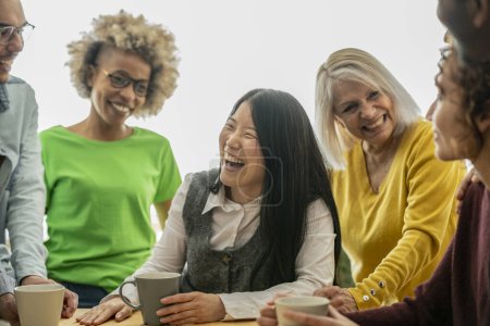 Photo for A lively and diverse office team shares laughter and genuine connections during a coffee break, highlighting a positive and inclusive work environment. - Royalty Free Image