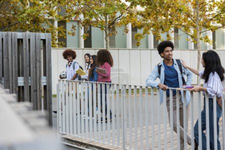 Diverse college students walking and chatting on a campus walkway during a sunny autumn day.