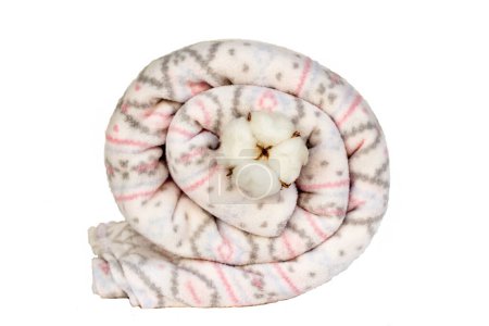 Téléchargez les photos : Couverture en laine douce, molleton enroulé dans un tourbillon avec une poupée en coton naturel isolé sur blanc - en image libre de droit
