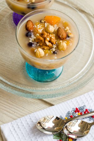 Téléchargez les photos : Asure traditionnelle de dessert turc, pudding de Noé dans des bols en verre élégants sur une table en bois - en image libre de droit