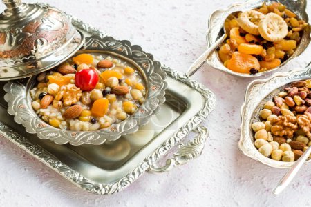 Téléchargez les photos : Dessert traditionnel turc Ashure et ingrédients Ashura, conçus dans des bols traditionnels en argent - en image libre de droit