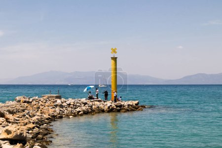 Téléchargez les photos : Le brise-lames de couleur jaune est au-dessus de la mer conçu avec des pierres décoratives. - en image libre de droit