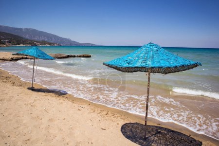 Téléchargez les photos : Plage calme avec parasols en paille bleue avec mer turquoise - en image libre de droit