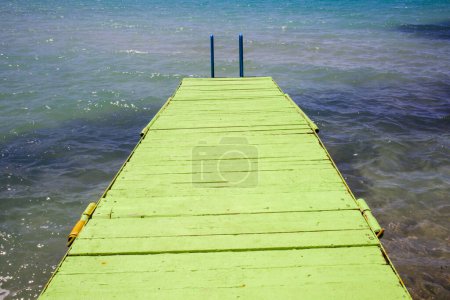 Téléchargez les photos : Masse en bois au-dessus de la mer bleue, avec escalier en fer, prise de vue rapprochée - en image libre de droit