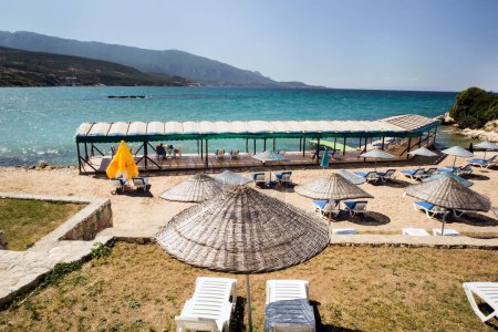Téléchargez les photos : Café de plage au-dessus de la mer avec chaises longues et parasols en paille - en image libre de droit
