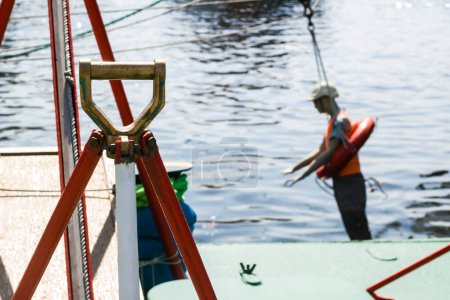 Téléchargez les photos : Mannequin homme sans vie en gilet de sauvetage et bouée de sauvetage suspendue par des cordes du navire au-dessus de la mer - en image libre de droit