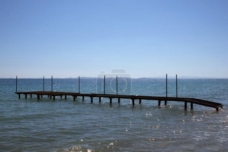 Téléchargez les photos : Passerelle en bois démantelée jetée rouillée dans la mer bleue - en image libre de droit