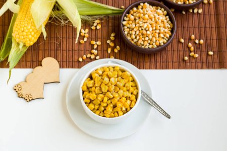 Téléchargez les photos : Maïs doux frais bouilli dans un bol blanc avec épis de maïs naturels et maïs séché - en image libre de droit